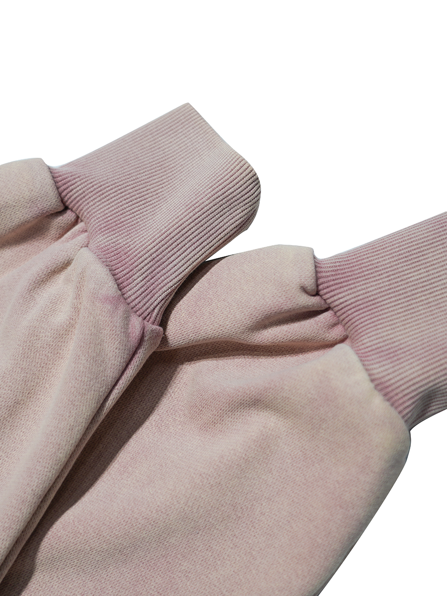 Close-up of a pink garment with pink ribbed cuffs on a white background