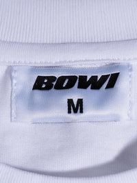 Close-up of a label on a white garment with 'BOWI' and size 'M'.