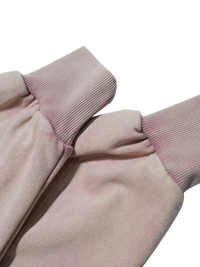 Close-up of a pink garment with pink ribbed cuffs on a white background