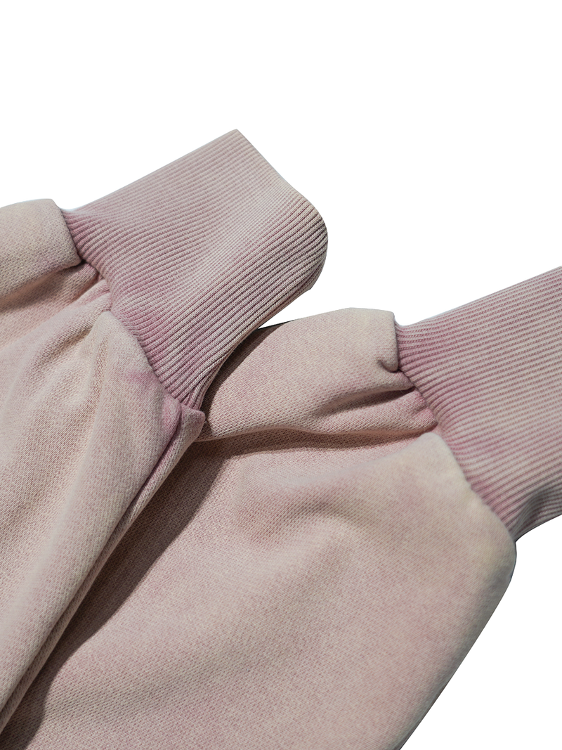 Close-up of a pink garment with pink ribbed cuffs on a white background