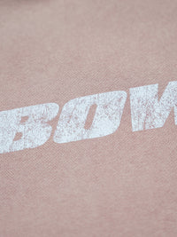 Close-up of a pink fabric with 'BOWI' printed in white.