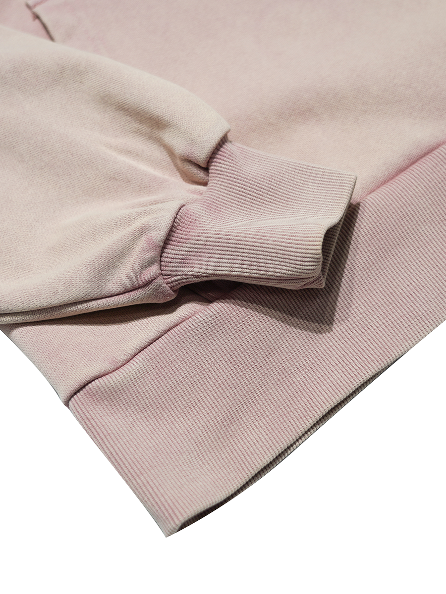 Close-up of a light pink hoodie with a soft texture on a white background