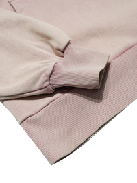 Close-up of a light pink hoodie with a soft texture on a white background