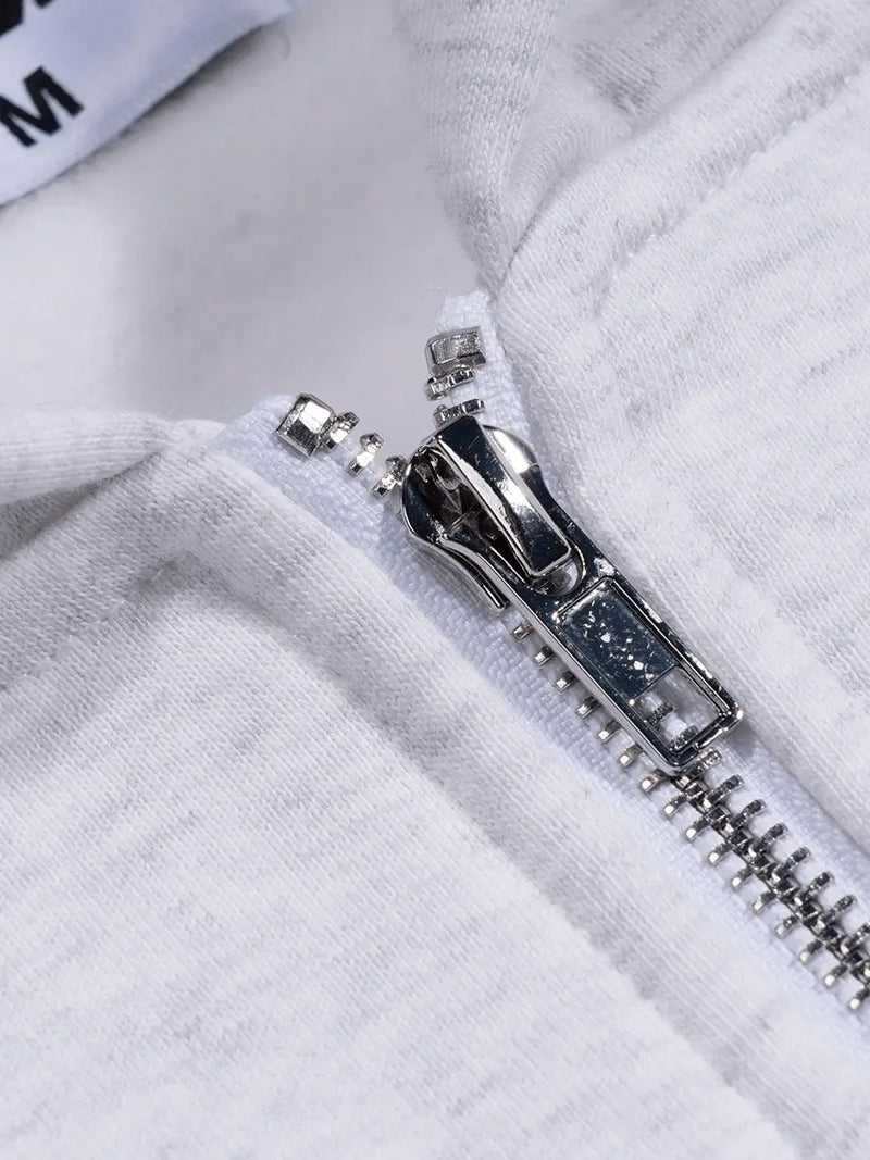 Close-up of a silver zipper on a gray fabric background