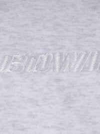 Close-up of a light gray sweatshirt with a brand logo on the chest.
